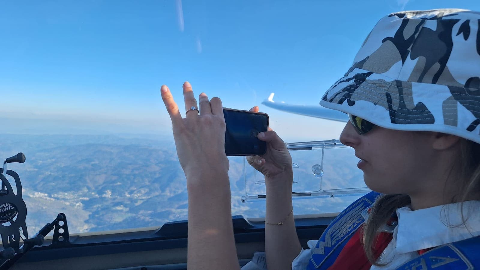 Eine Passagierin fotografiert die tief unter ihr liegenden Alpen aus dem Cockpit der Stemme S10