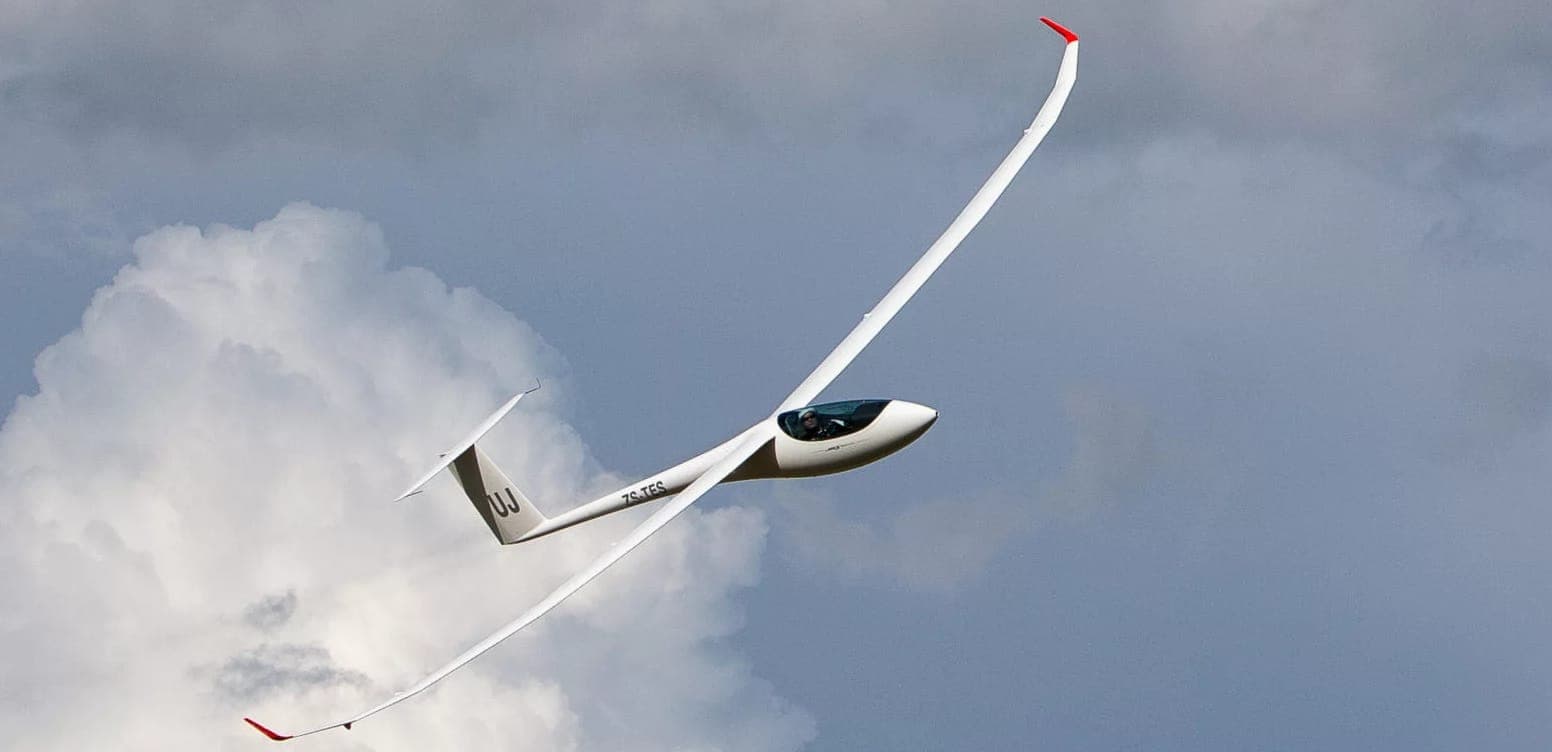Ein JS3-Hochleistungs-Segelflugzeug im Kurvenflug vor Quellwolken