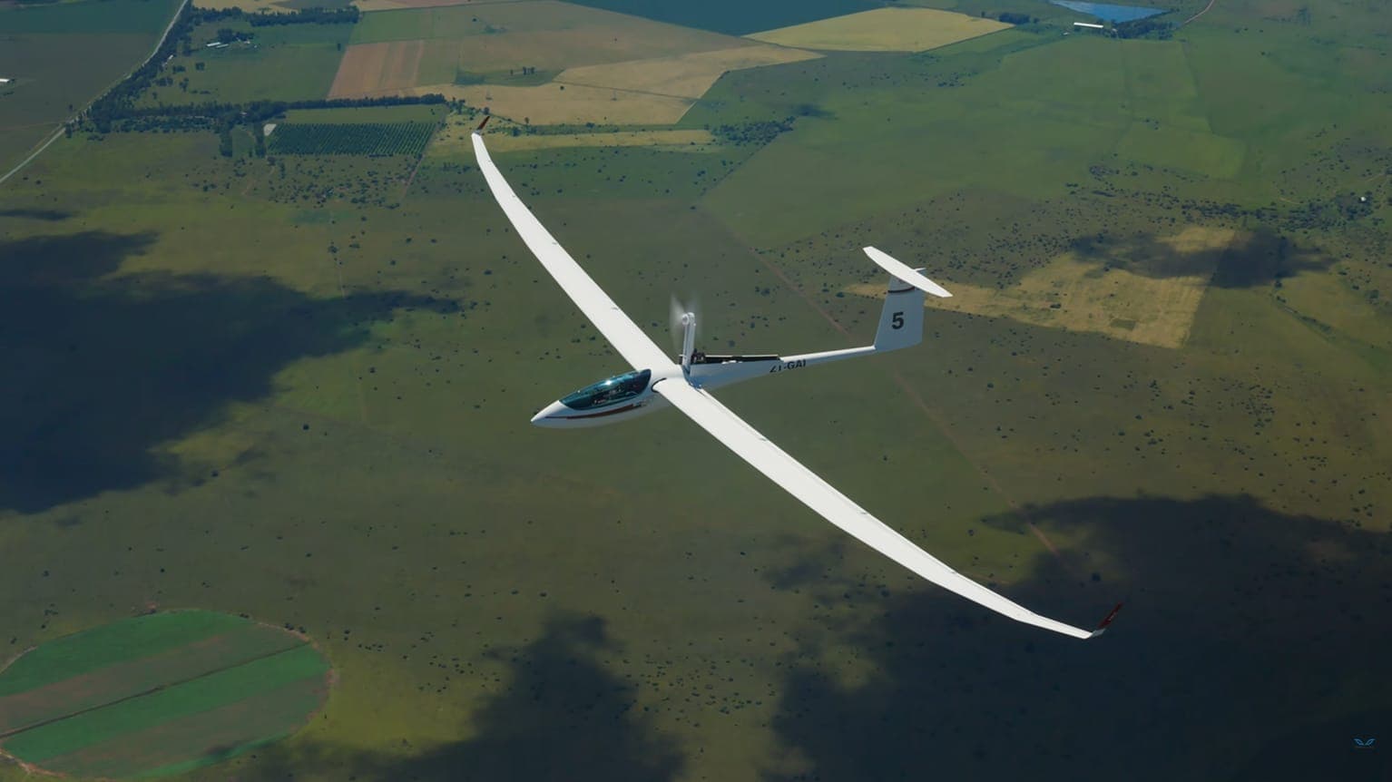 Ein JS5 Rey Segelflugzeug im Flug über offenem Gelände