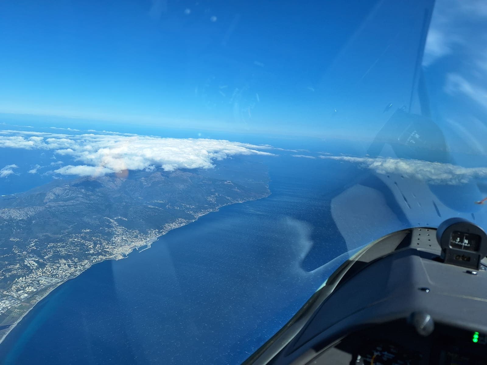 The Corsican coast and open sea ahead of the cockpit, on course towards Italy