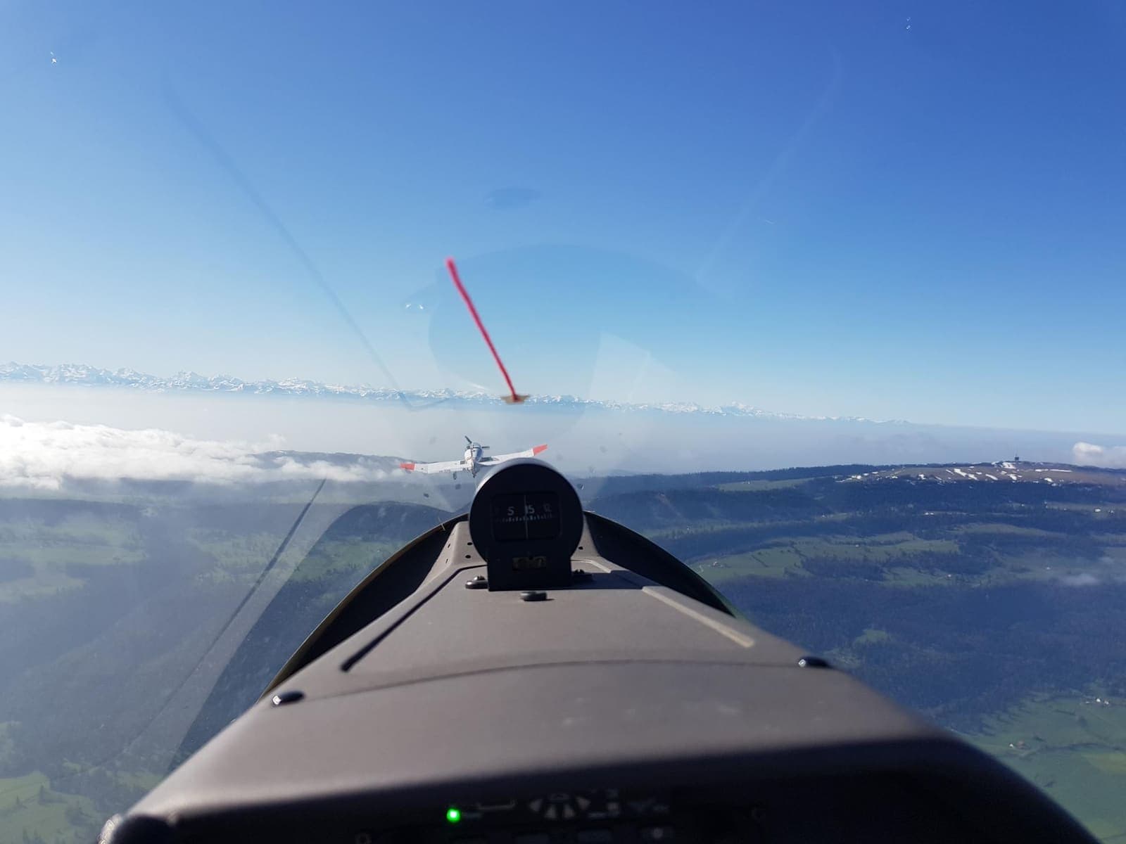 Cockpitblick über eine geschlossene Nebeldecke an der Schweizer Grenze am frühen Morgen