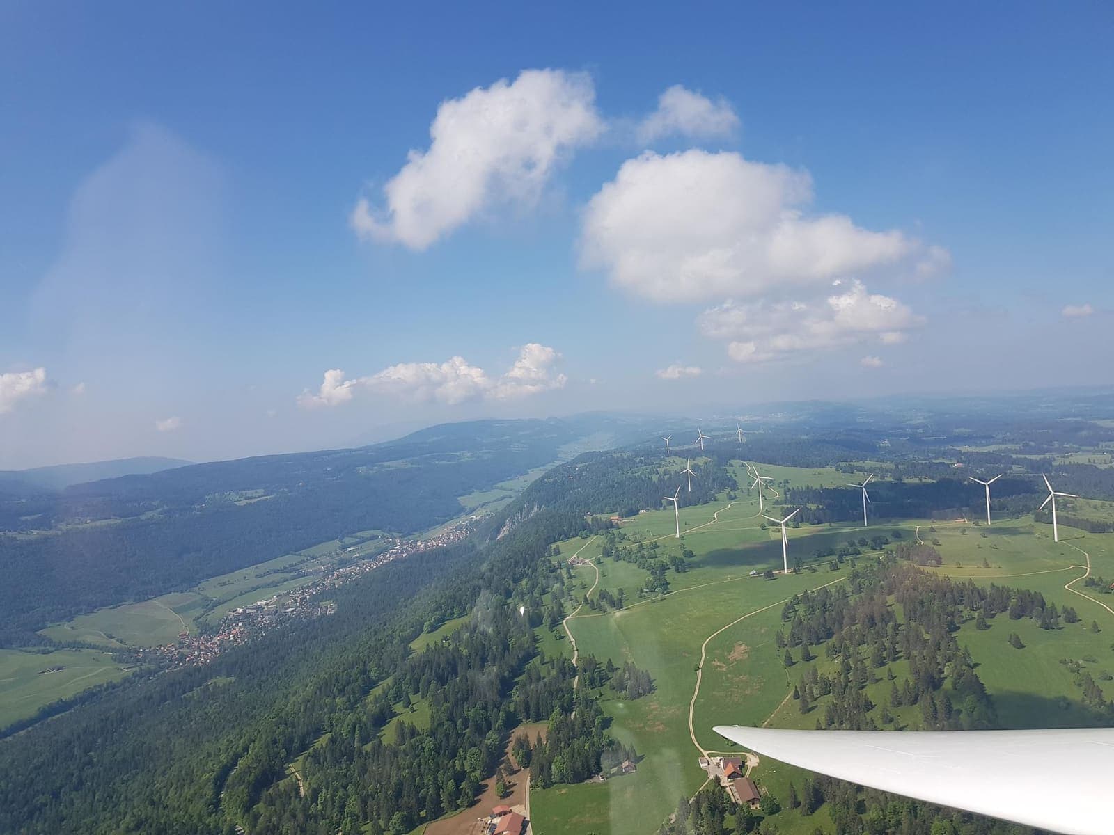 The wooded Jura ridge with wind turbines shortly after departure from Courtelary